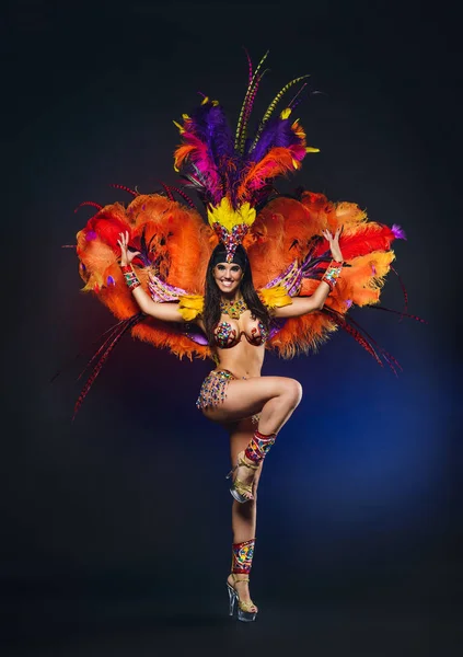 Linda chica joven en traje de carnaval de colores brillantes en la espalda oscura — Foto de Stock