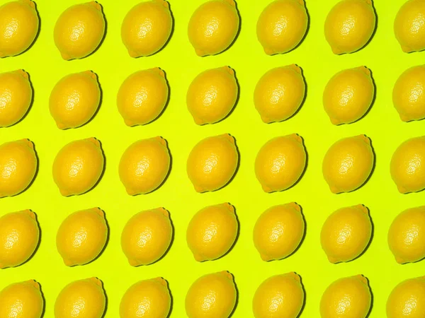 Colorful fruit pattern of fresh lemons on a light green background. Top view