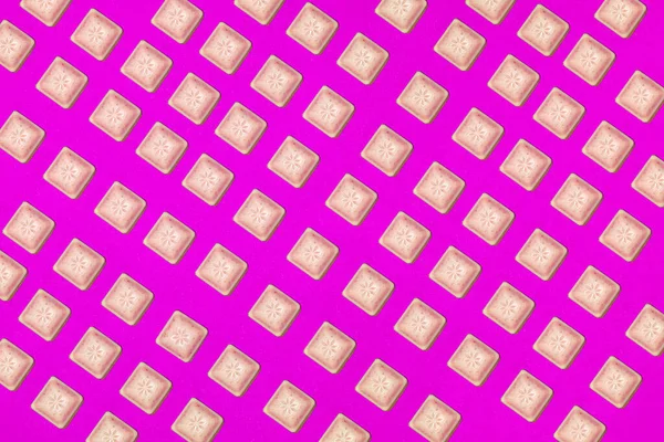 Colorful pattern of chocolate slices on a purple background. Top view