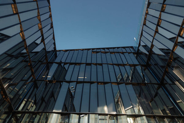 Glass facades of modern office buildings and reflection of blue sky