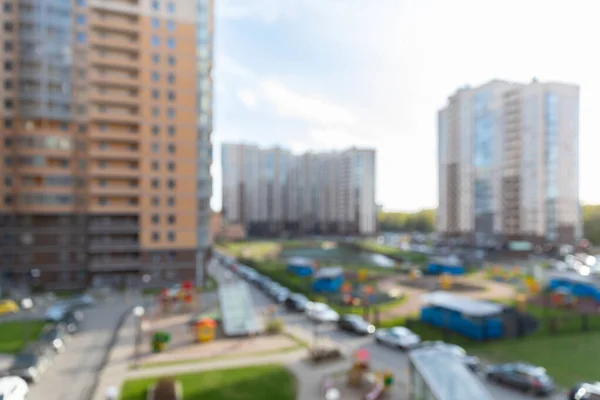 Yazın geniş, çok katlı bir sitenin bulanık avlusunda arabalar için park yerleri var. Tasarım için bulanık temel bokeh arkaplanı.