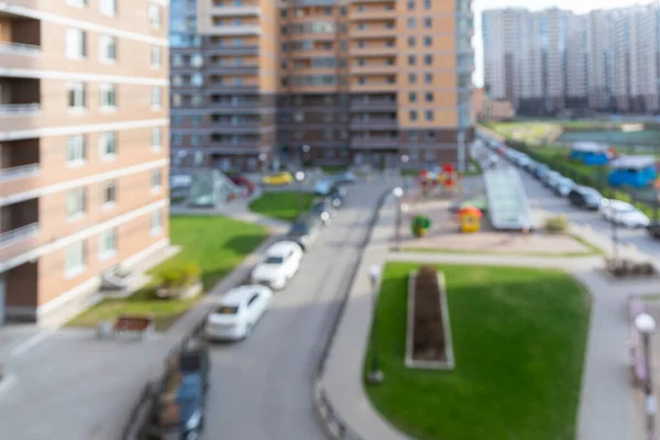 Yazın geniş, çok katlı bir sitenin bulanık avlusunda arabalar için park yerleri var. Tasarım için bulanık temel bokeh arkaplanı.