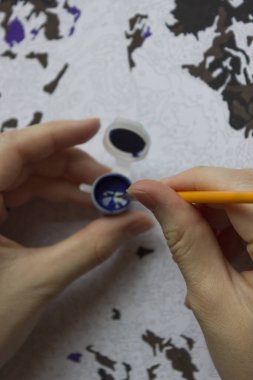 Rakamlara göre resim. Tuvale resim çiziyorum. Numaralı boya kutuları. Yaratıcı hobi. Seçici odaklanma. Kapat. Akrilik boyalarla numaralar çizerek. Karantinaya alınmış eğlence..