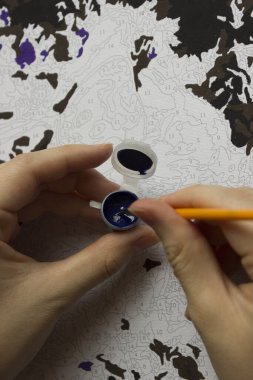 Rakamlara göre resim. Tuvale resim çiziyorum. Numaralı boya kutuları. Yaratıcı hobi. Seçici odaklanma. Kapat. Akrilik boyalarla numaralar çizerek. Karantinaya alınmış eğlence..