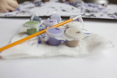 Rakamlara göre resim. Tuvale resim çiziyorum. Numaralı boya kutuları. Yaratıcı hobi. Seçici odaklanma. Kapat. Akrilik boyalarla numaralar çizerek. Karantinaya alınmış eğlence..