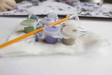 Rakamlara göre resim. Tuvale resim çiziyorum. Numaralı boya kutuları. Yaratıcı hobi. Seçici odaklanma. Kapat. Akrilik boyalarla numaralar çizerek. Karantinaya alınmış eğlence..