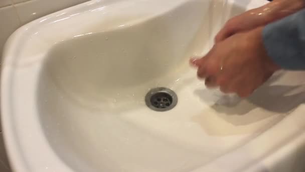 Una mano che tiene un lavandino bianco.man si lava le mani con il sapone sopra il lavandino — Video Stock