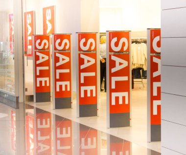 Alışveriş merkezindeki mağazanın girişinin dekorasyonu. Kırmızı arka planda beyaz harfli tabela satışı