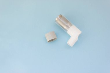 Mavi arka planda Dünya Astım Günü 5 Mayıs anti-astım spreyi.