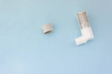 Mavi arka planda Dünya Astım Günü 5 Mayıs anti-astım spreyi.