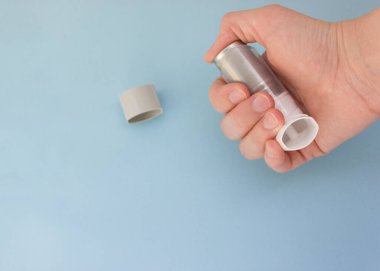 Mavi arka planda Dünya Astım Günü 5 Mayıs anti-astım spreyi.