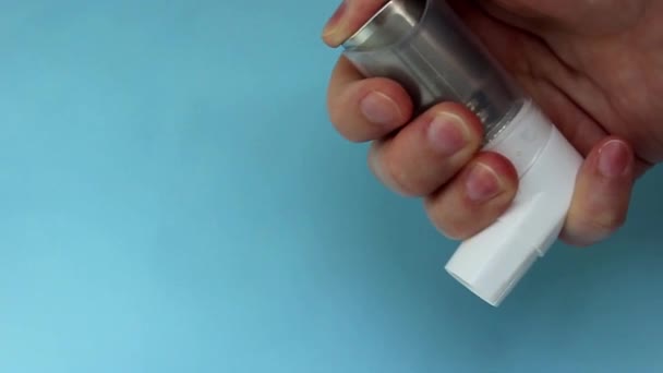 Всемирный день астмы 5 мая Ингалятор против астмы на синем фоне — стоковое видео