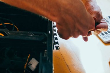 Kıdemli erkek teknisyen donanım tamir tesisinde çalışıyor. Adam bir bilgisayar monte ediyor..