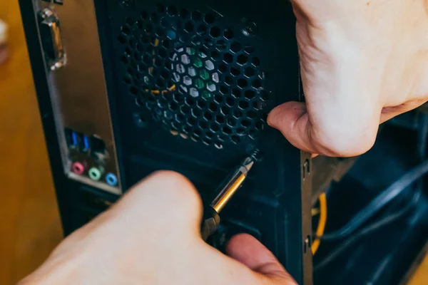 Senior male tech works in hardware repair facility.guy is assembling a computer.