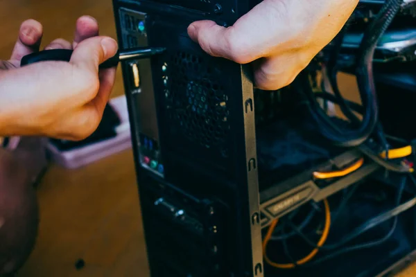 Senior male tech works in hardware repair facility.guy is assembling a computer.