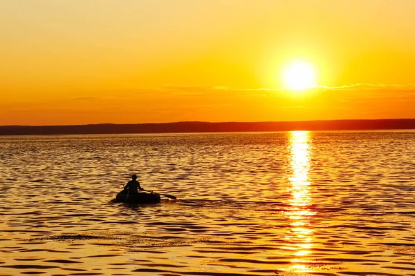 Silhouet Een Mannelijke Visser Een Opblaasbare Boot Drijft Bij Zonsondergang — Stockfoto