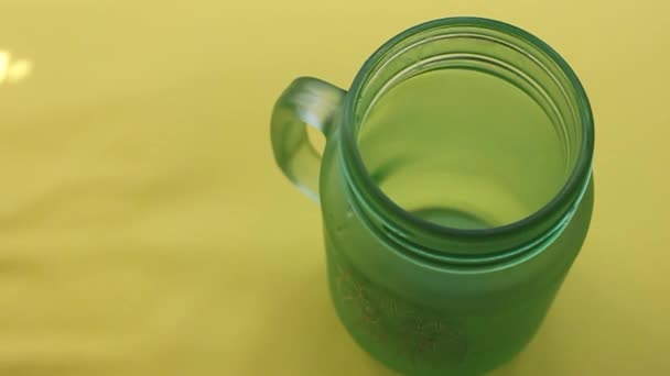 Ρίξτε το γάλα από μια συσκευασία σε ένα ποτήρι σε κίτρινο φόντο.1η Ιουνίου Παγκόσμια Ημέρα Γάλακτος — Αρχείο Βίντεο