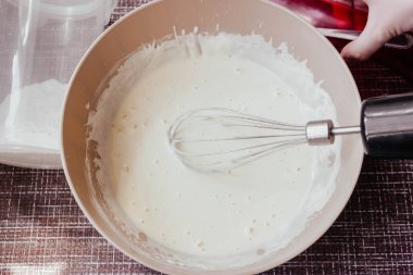 Mutfakta çırpılmış çırpılmış krep ya da omlet yapmak için hamur. Süzme peynirden yapılan ev yapımı sağlıklı krepler. krep talimatı. Adım adım. Krep için hamur yapmak..