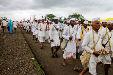 Hac yürüyüşü yapan, dans eden ve dini şarkılar söyleyen mihraci insanlar.