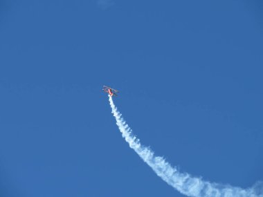 Mavi gökyüzünde küçük akrobatik hava aracı ve patika