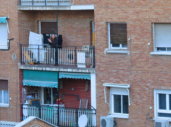 A proud woman applaudes from her balcony during the quarantine due to Coronavirus emergency