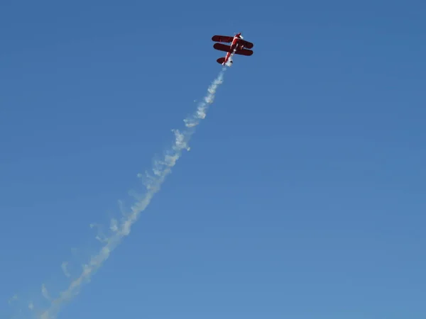 Kleine acrobatische vliegtuigen en trail in de blauwe lucht — Stockfoto