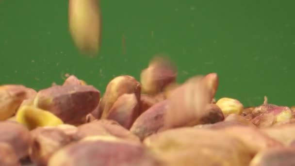 Pistácie ořechy pádu v makro extrémní pomalý pohyb zelený box — Stock video