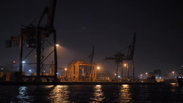 Контейнерный морской порт и общественный пароход, проходящий ночью в Стамбуле — стоковое видео