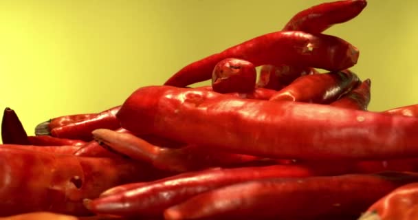 Extreme Makroaufnahme roter Chilischoten mit rotierendem gelben Hintergrund — Stockvideo