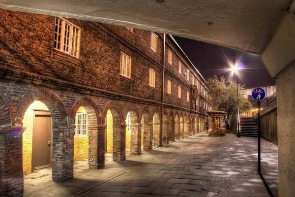 Traditional Red Brick Building with Arcade along Quiet Street At Night in Newcastle upon Tyne, UK