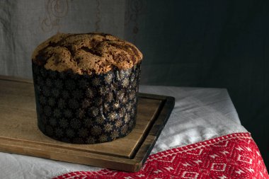 Tahta üzerinde Paskalya pastası ve desenli masa örtüsü.