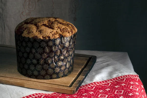 Tahta üzerinde Paskalya pastası ve desenli masa örtüsü.