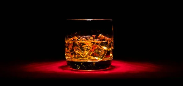 Ein Glas Whisky Auf Den Felsen Auf Dem Roten Tisch Stockbild