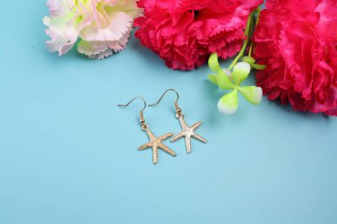 Mavi arkaplanda altın yıldız küpeler