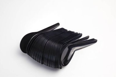 Beyaz arkaplanda siyah plastik kaşıklar var.