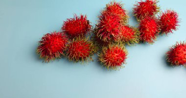 Taze Rambutan, mavi arka planda Tayland meyveleri.