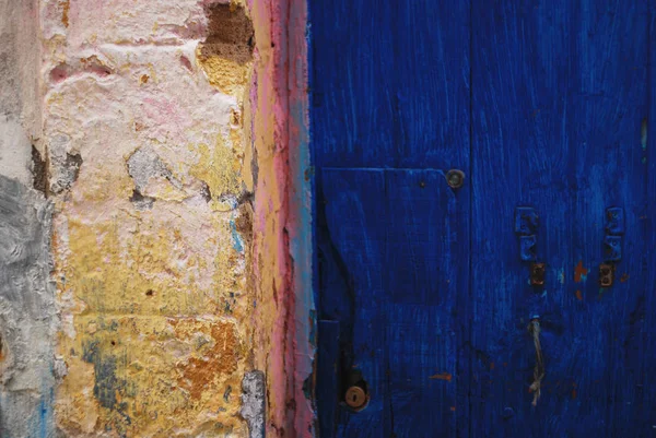 Brillante pared de hormigón colorido y una puerta azul — Foto de Stock