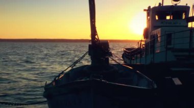 Tekne gün batımında nehirden geçiyor.