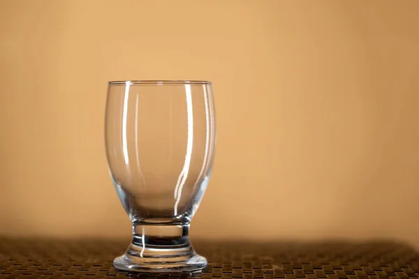 質感のテーブルとベージュの背景に空の透明なガラスワイングラス — ストック写真