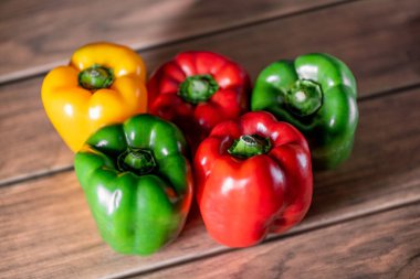 Birçok taze dolma biber organik farklı renktedir. Tahtada kırmızı sarı ve yeşil.