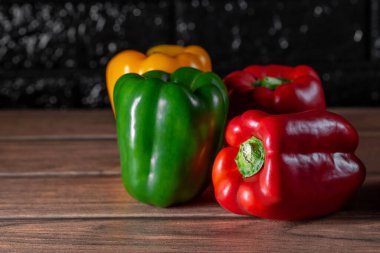 Tahtada farklı renkte dört büyük dolma biber.