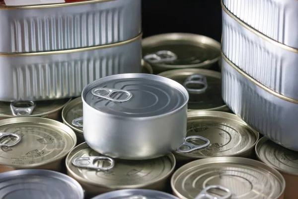 tuna can and many canned tuna and sardines silver and gold color and black background