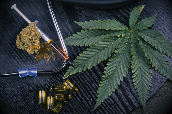 Medizinische Marihuanaprodukte mit Cannabisblatt auf schwarz — Stockfoto