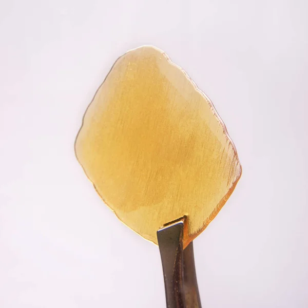 Um pedaço de óleo de cannabis concentrado ou seja, estilhaçar isolado no whit — Fotografia de Stock