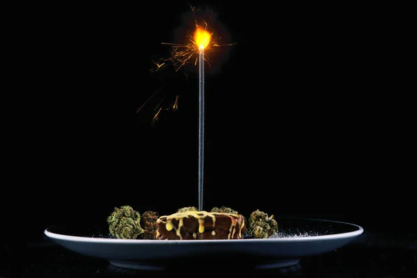 Pot brownie with candle isolated on black — Stock Photo, Image