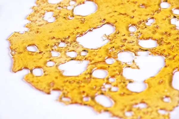 Piece of cannabis oil concentrate aka shatter isolated against w — Stock Photo, Image