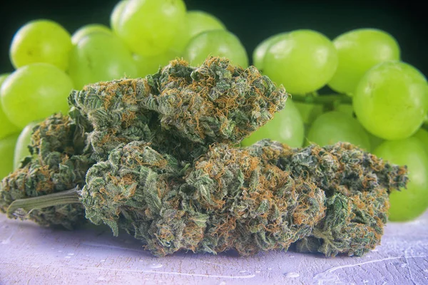 Dried cannabis buds (Grape Ape strain) with fresh fruit - medica — Stock Image Dried cannabis buds (Grape Ape strain) with fresh fruit - medica Stock Picture