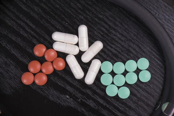 Detalhe de pílulas farmacêuticas variadas sobre preto — Fotografia de Stock