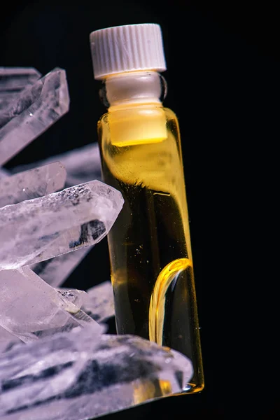 Recipiente de óleo de cannabis e cristal de quartzo isolado em preto — Fotografia de Stock