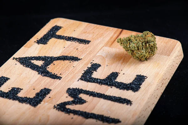 Bourgeon de cannabis sur une surface en bois avec les mots "mange-moi" - medic — Photo